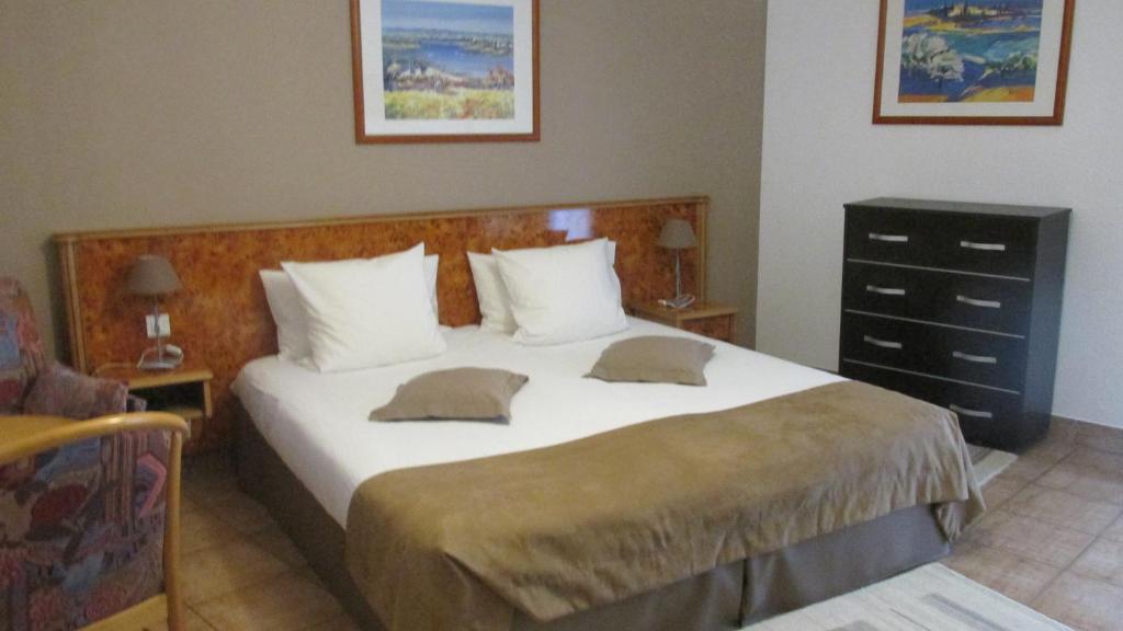 a bedroom with a large bed with white sheets and pillows at Hôtel sud alsace in Ranspach-le-Bas