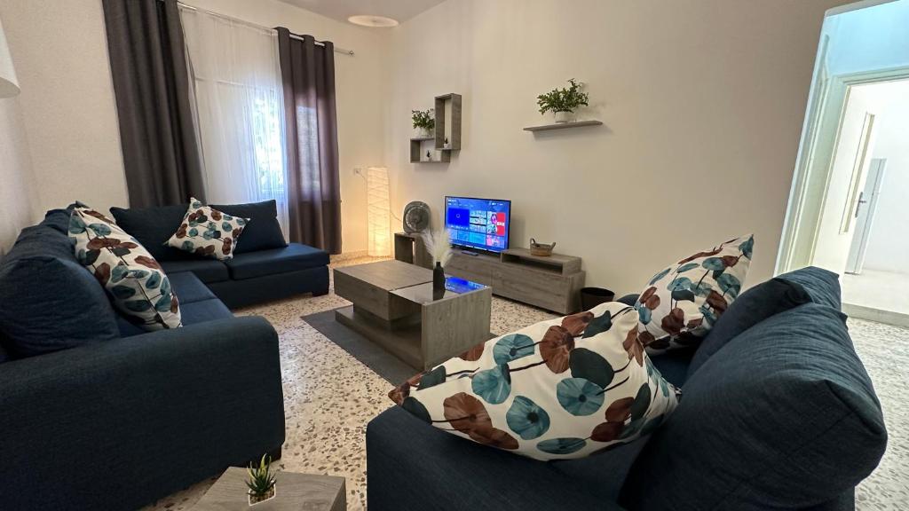 a living room with two blue couches and a tv at Turkuaz Aparment in Amman
