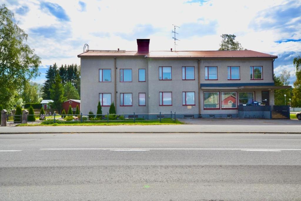 un edificio al lado de una calle con una carretera en Poppeli Guest House, en Kannus