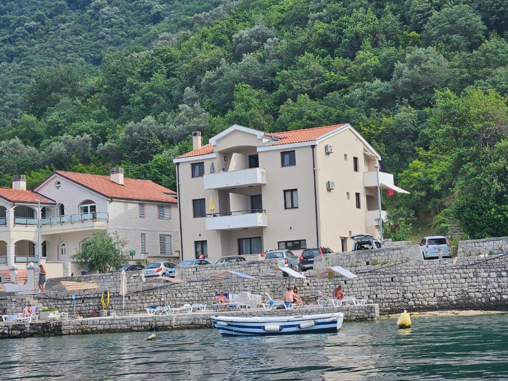 a small boat on the water in front of a building at Apartmani Račeta in Kotor
