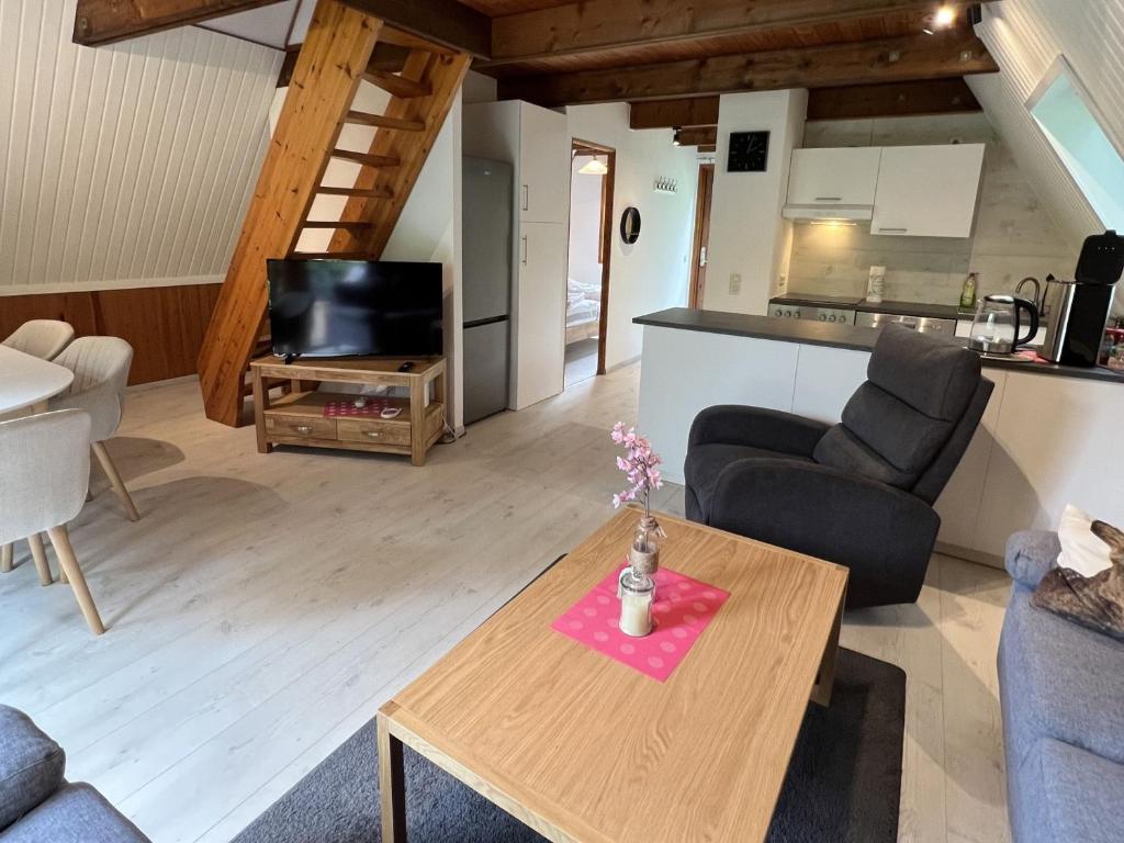 ein Wohnzimmer mit einem Tisch und einer Küche in der Unterkunft Twistesee Ferienhaus 42 in Bad Arolsen
