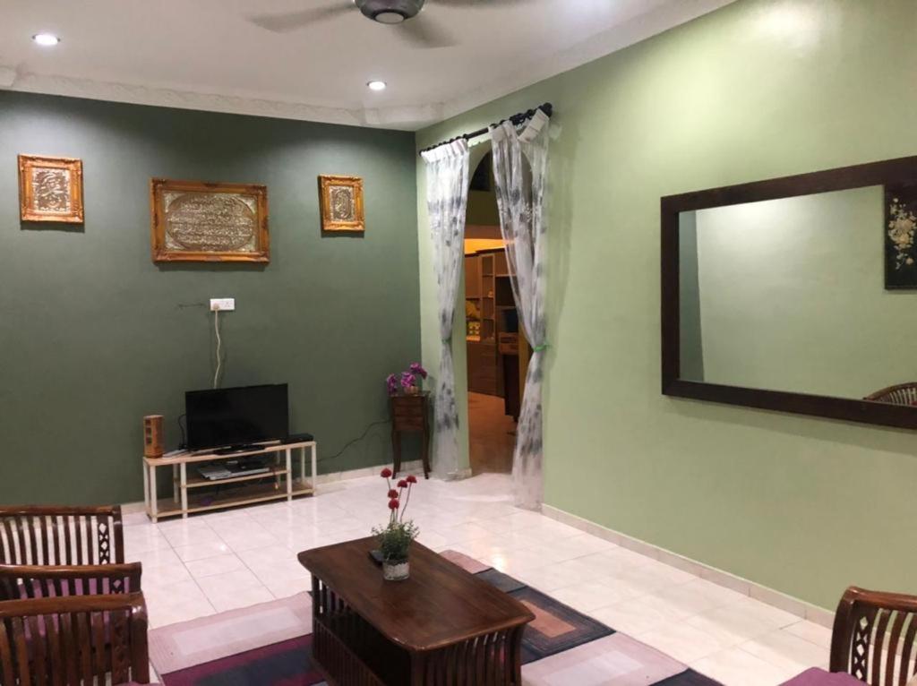 a living room with a large mirror on the wall at KJ Homestay Balok Kuantan in Kampong Chengal Lempong