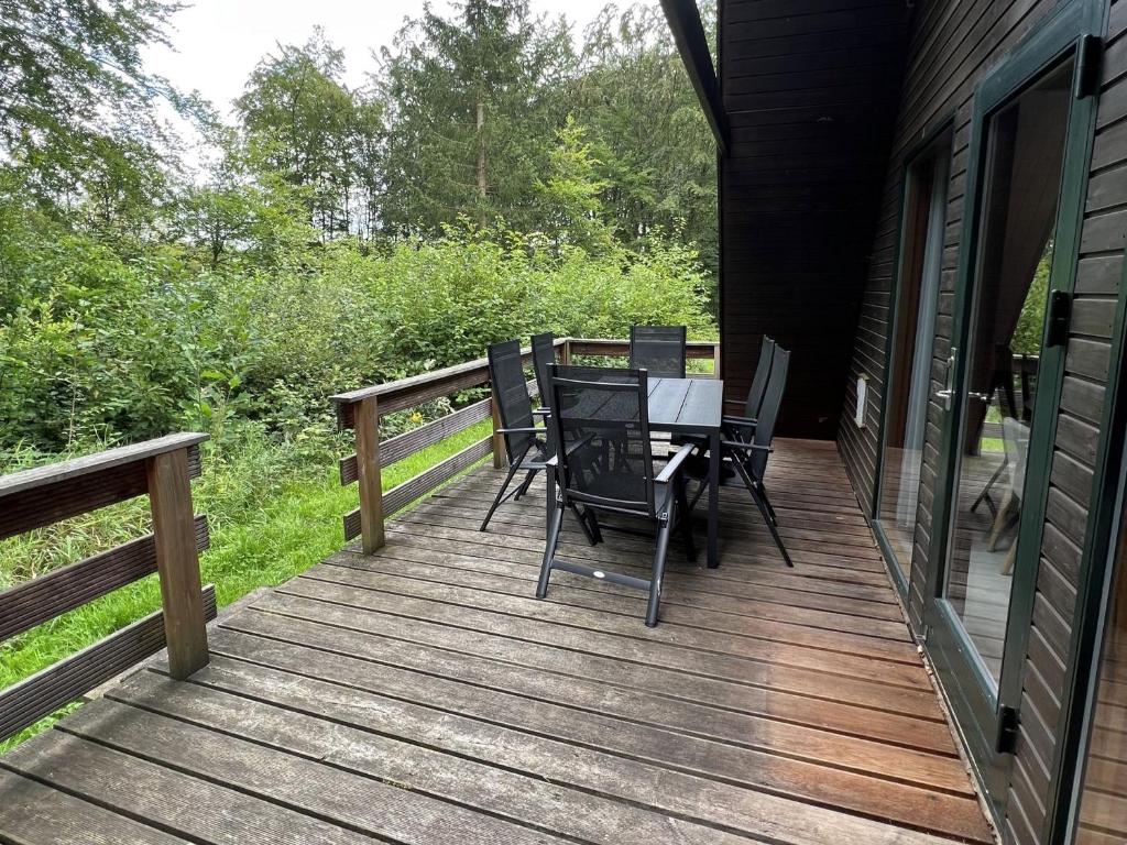 a wooden deck with a table and chairs on it at Twistesee Ferienhaus 42 in Bad Arolsen