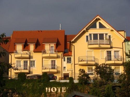un gran edificio de apartamentos con una señal de hilton delante de él en Hotel am Schloss, en Dippoldiswalde