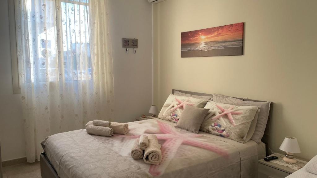 una camera da letto con un letto e pantofole di Il profumo del mare a Marina di Mancaversa