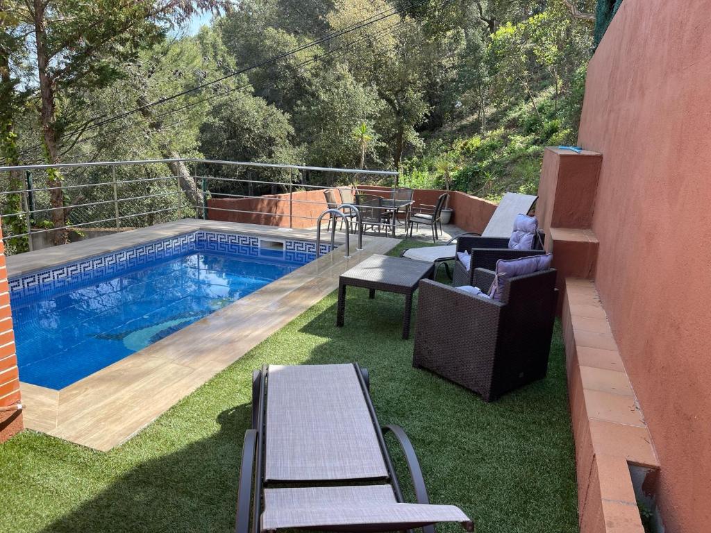 a backyard with a swimming pool and some chairs at Villa for 2 families in Blanes