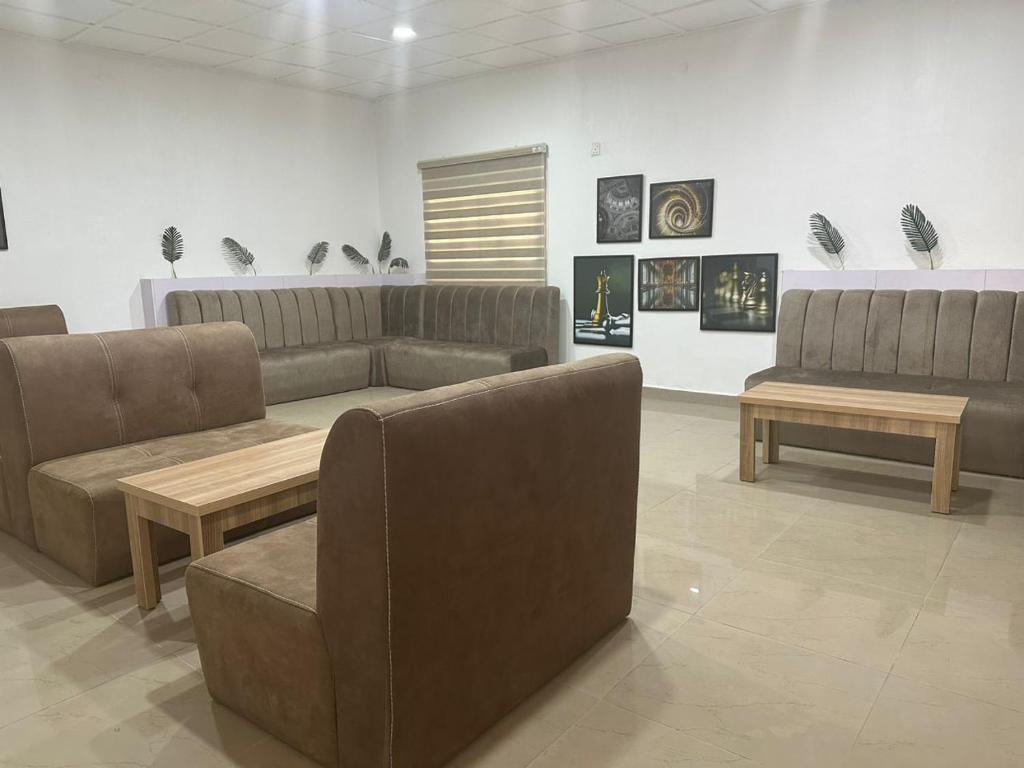a living room with couches and tables in a room at Blissful Lodgings in Jos