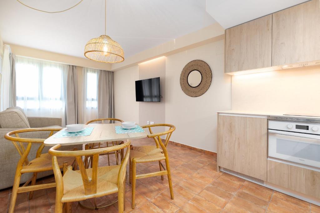 Una cocina y un comedor con mesa y sillas. en Apartamentos Las Ciencias I, en Valencia