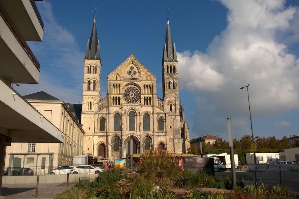 Une grande cathédrale avec deux flèches en haut dans l'établissement Vue sur la Basilique 'St 'Rémi, à Reims