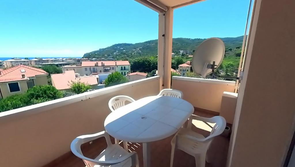 una mesa y sillas en un balcón con vistas en Casa Enry, en Spotorno