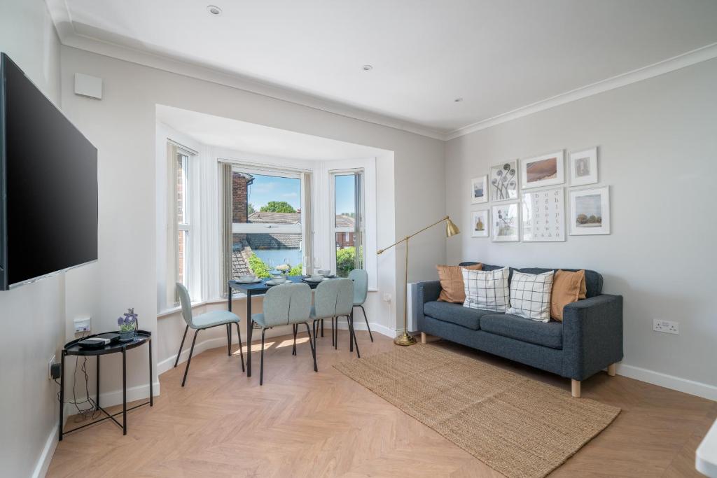 a living room with a blue couch and a table at Skyline Serviced Apartments - Julians Road in Stevenage