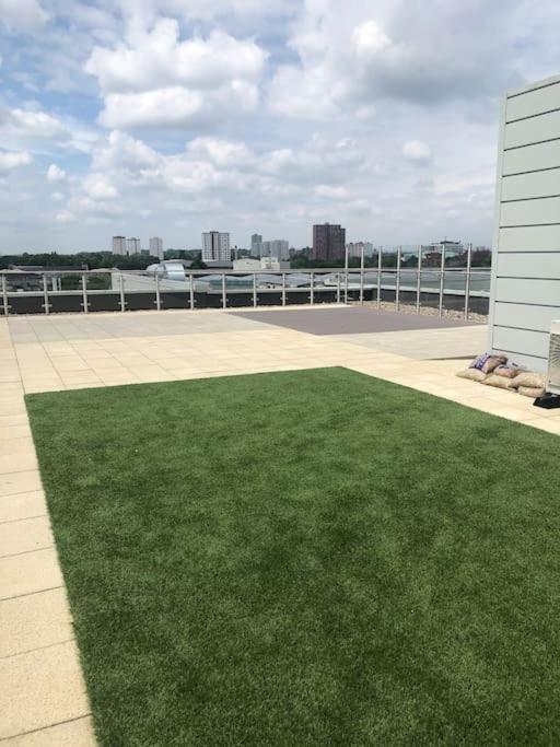 a field of green grass next to a building at 3 bedroom apartment free parking in Manchester