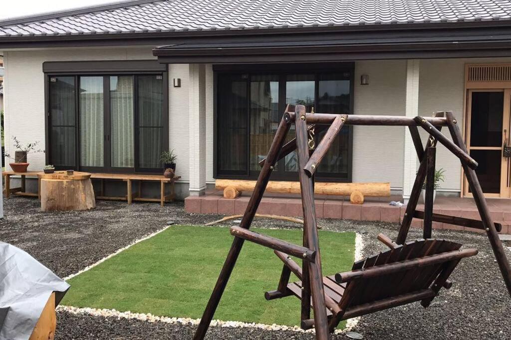 菊川市的住宿－SOZENSYA 駅、高速インターに近い新築日本家屋です。庭が広く、BBQも楽しめます。，房子前面的院子中秋千