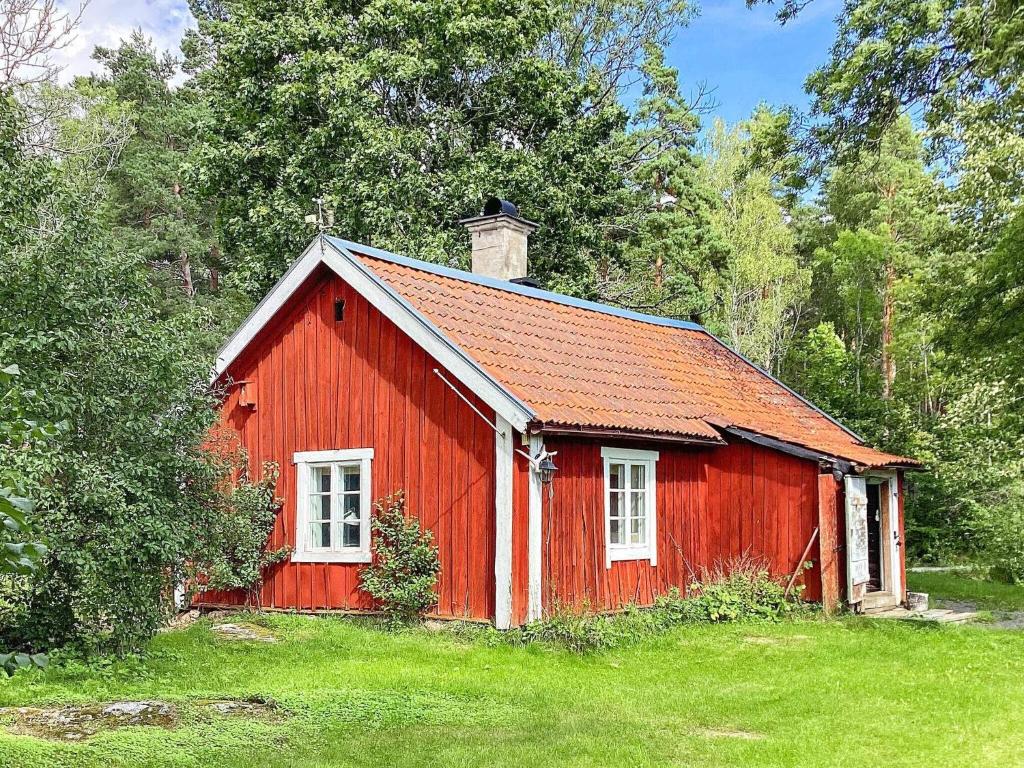 a red barn in the middle of a field at Holiday home Uppsala in Uppsala