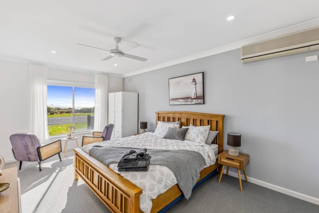 Un dormitorio con una cama grande y una ventana. en Oceanfront Odyssey, en Portarlington