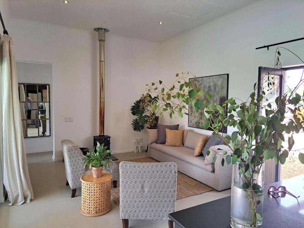 - un salon avec un canapé et une table dans l'établissement KARENINA'S Self-catering Accommodation, à Riebeek-Kasteel