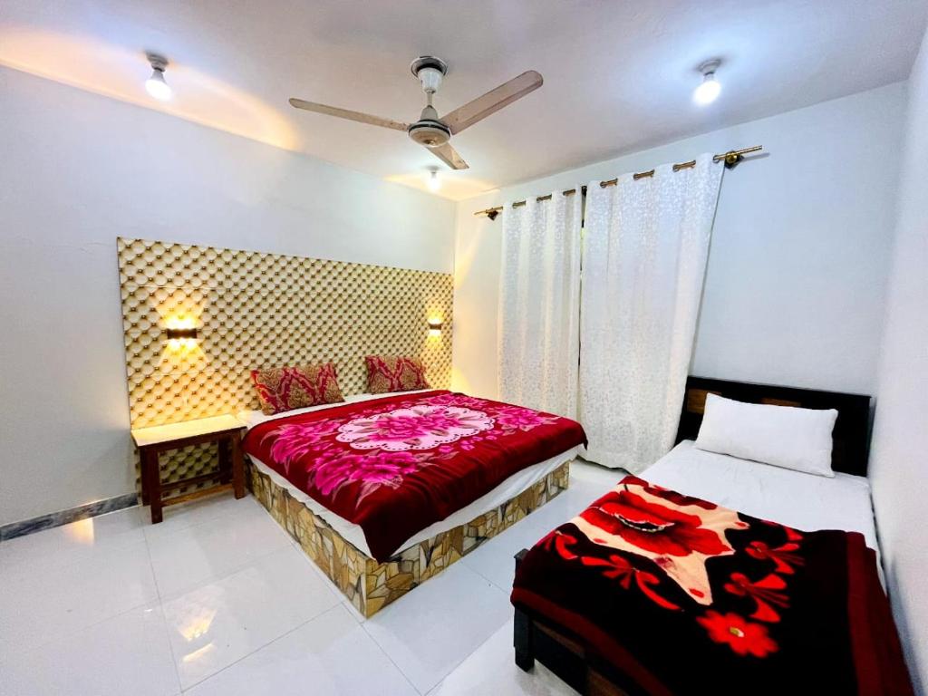 Serene Guest House في سكردو: غرفة نوم بسريرين مع شراشف حمراء وستائر