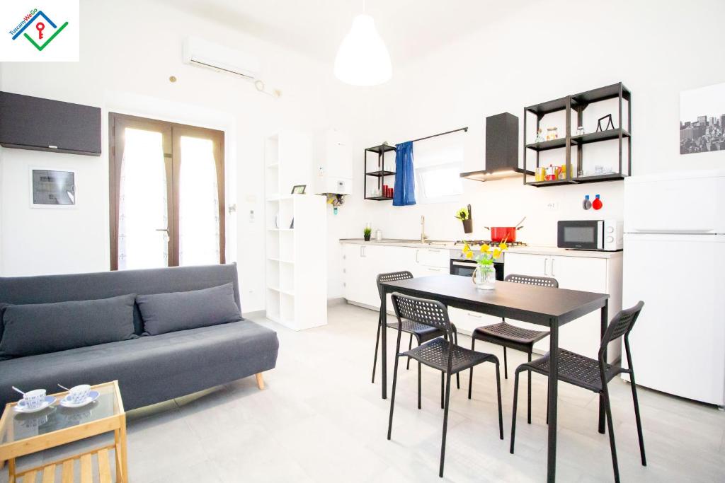 ein Wohnzimmer mit einem Sofa, einem Tisch und Stühlen in der Unterkunft LeS House - Apartment 1 in Pisa