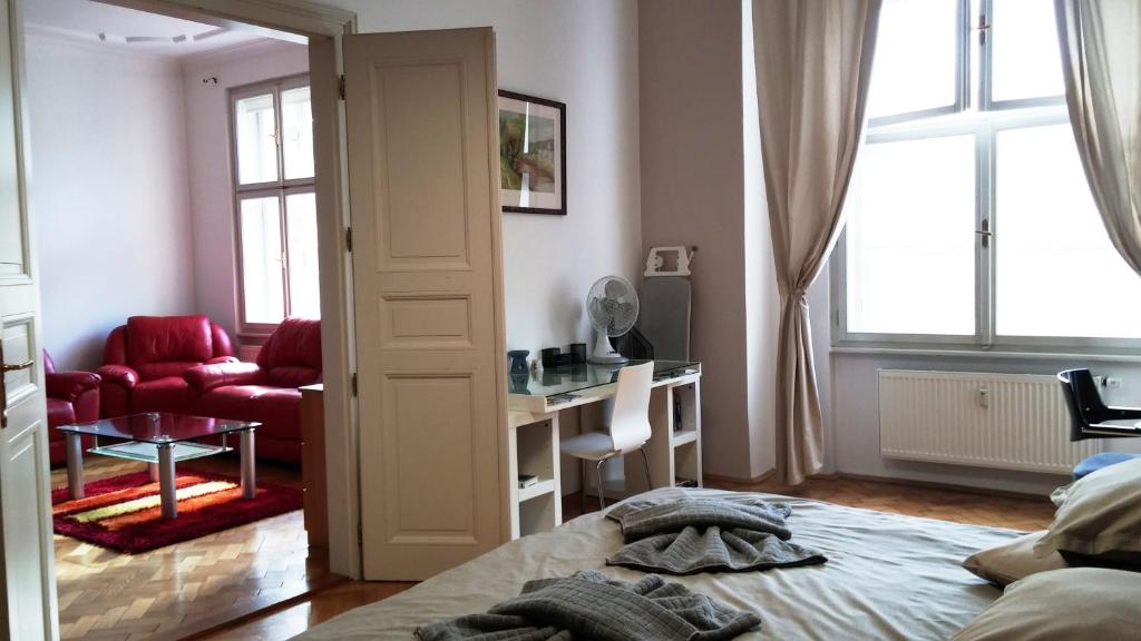 1 dormitorio con cama, escritorio y ventana en Apartment Balbínova, en Praga
