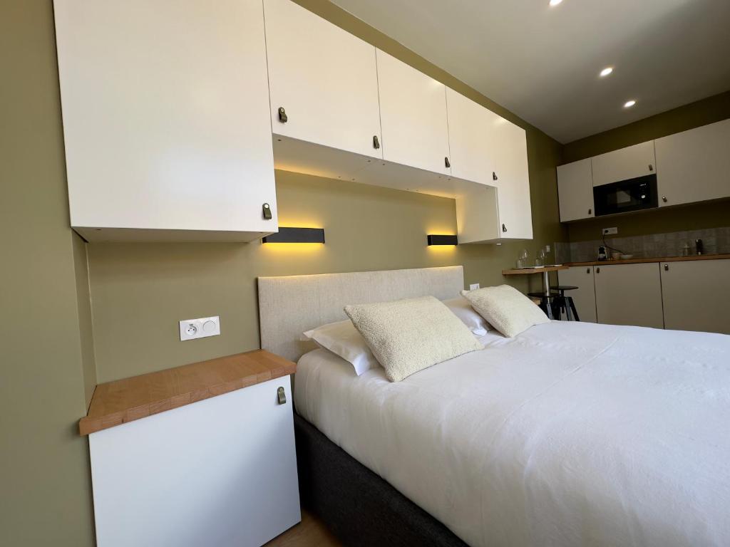 - une chambre avec un lit blanc et des armoires blanches dans l'établissement My Little Home - Le Vieux Lille de St Etienne, à Lille
