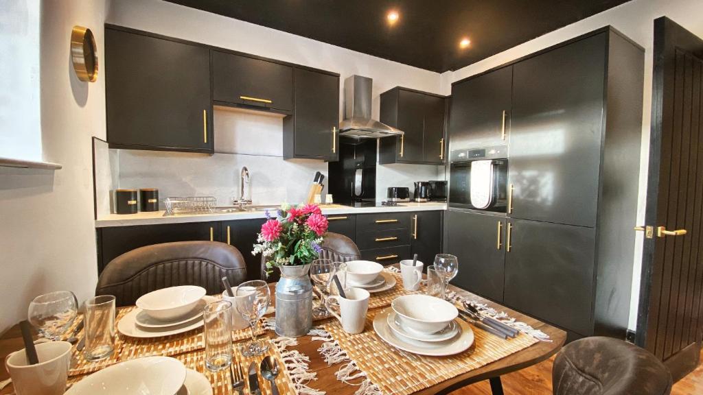 a kitchen with a table with plates and flowers on it at The Beaumonts in Darlington