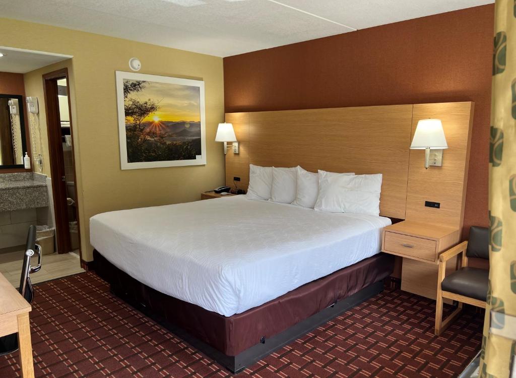 a hotel room with a large bed and a desk at Serenity Inn Sweetwater in Sweetwater