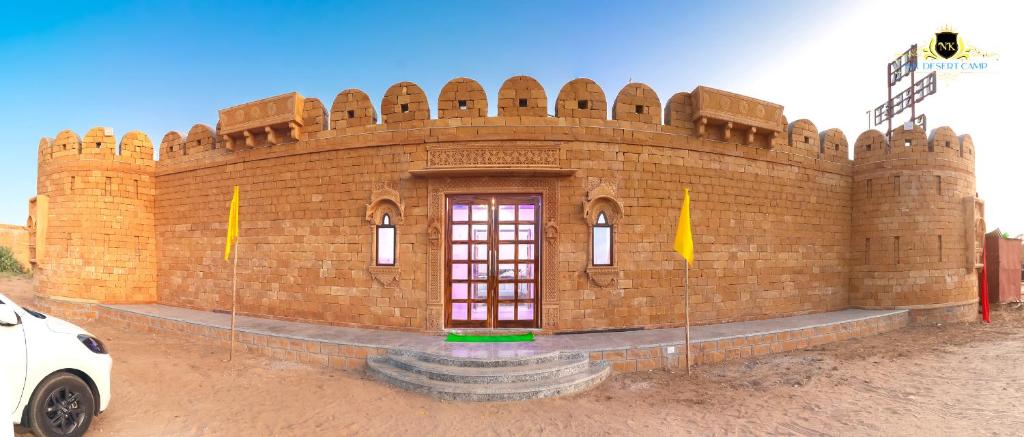 een groot bakstenen gebouw met een rode deur erop bij NK Desert Camp Jaisalmer in Sām