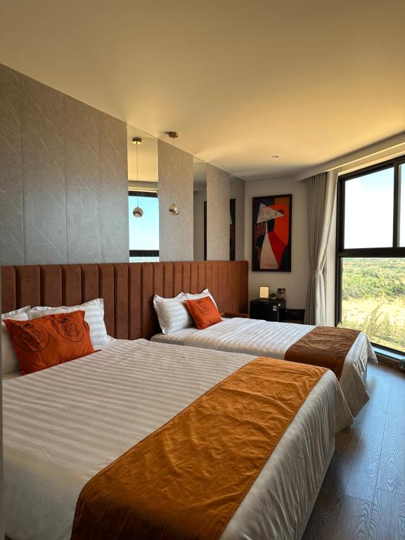 1 dormitorio con 2 camas con almohadas de color naranja en S0410 Apec Mui Ne en Ấp Thiẹn Ái