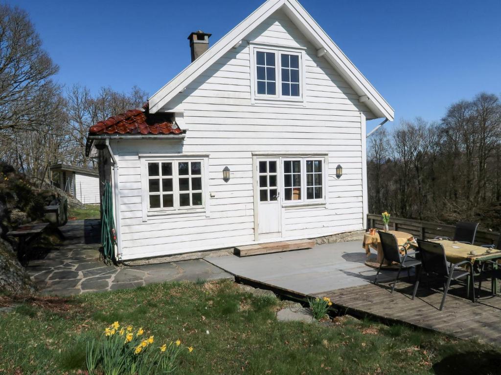 uma casa branca com um pátio e uma mesa em Holiday Home Sjøhytta - FJH675 by Interhome em Bekkjarvik