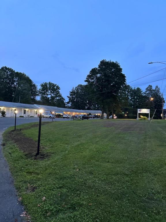 a parking lot with a light pole in the grass at Heart of the Berkshires Motel in Pittsfield