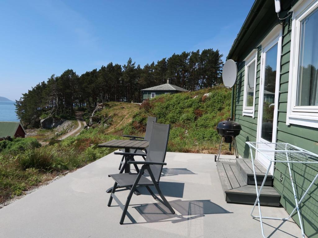 einen Tisch und Stühle auf der Veranda eines Hauses in der Unterkunft Holiday Home Sognesjön - FJS128 by Interhome in Bø