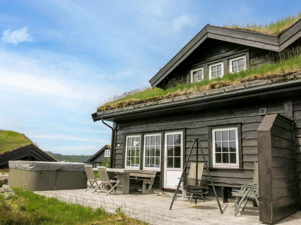 una casa con techo de hierba, mesa y sillas en Holiday Home Fjellheimen - SOW138 by Interhome en Åseral