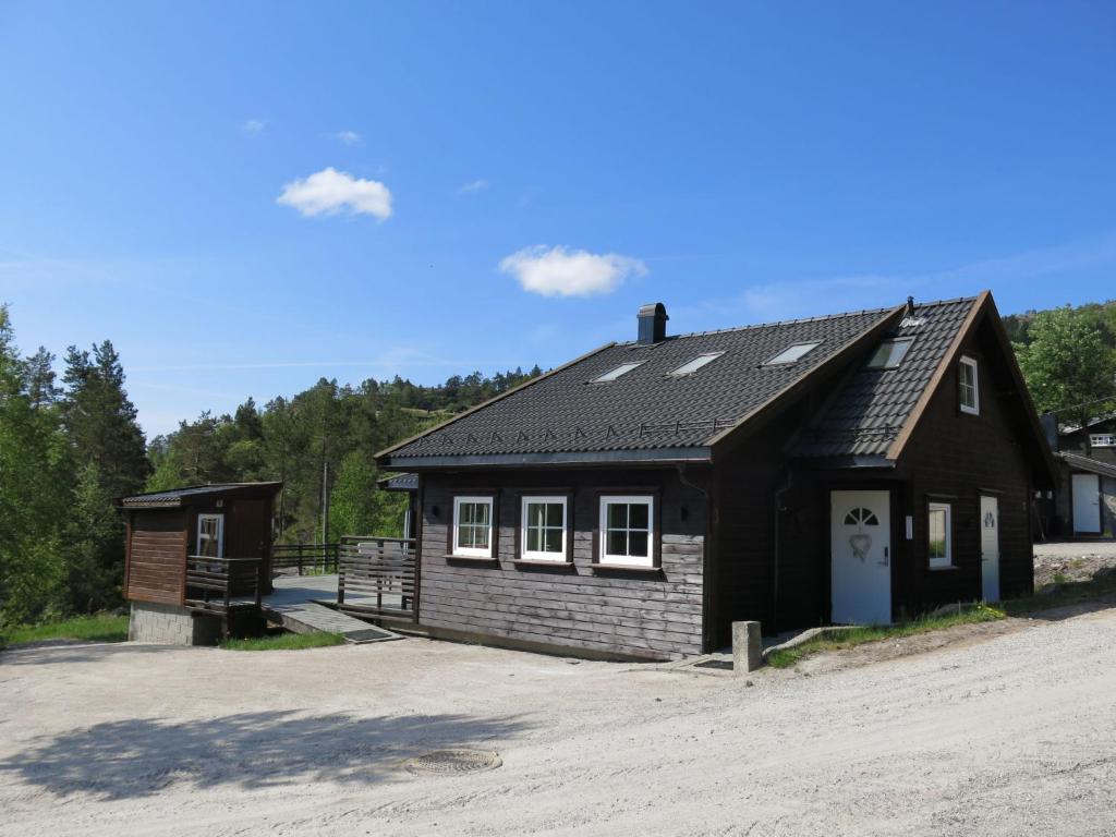 a small black building with a parking lot at Holiday Home Revenbu - SOW071 by Interhome in Fossdal