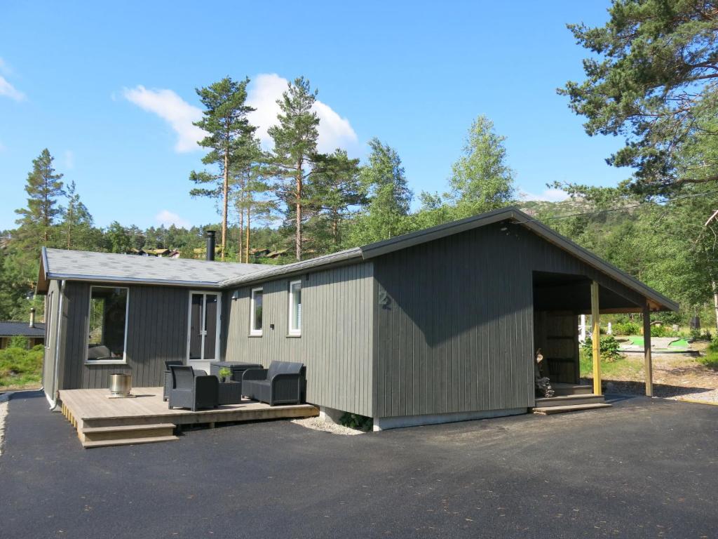 a small gray building with chairs in a parking lot at Holiday Home Bjørkstue - SOW149 by Interhome in Fossdal