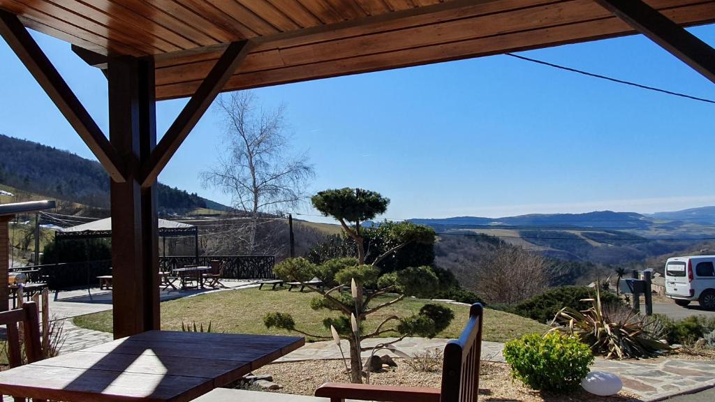 a patio with a table and a view of a valley at Chalet Le Chant des Etoiles in Mende