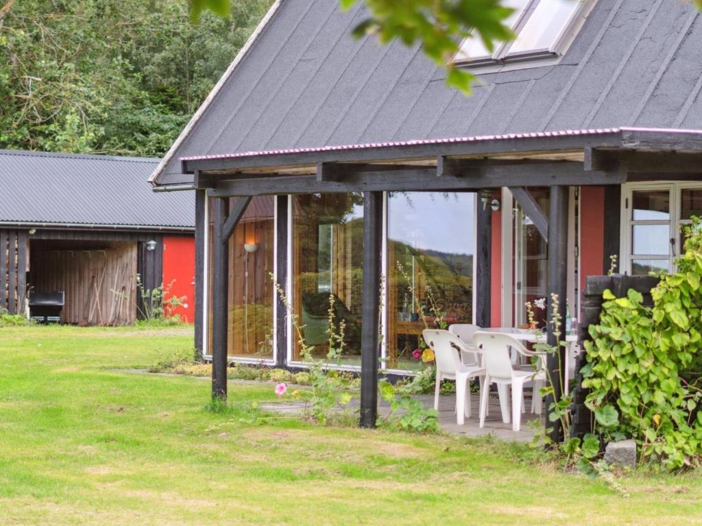 una casa con tavolo e sedie in cortile di Holiday Home Thana - 8km from the sea in Bornholm by Interhome a Gudhjem