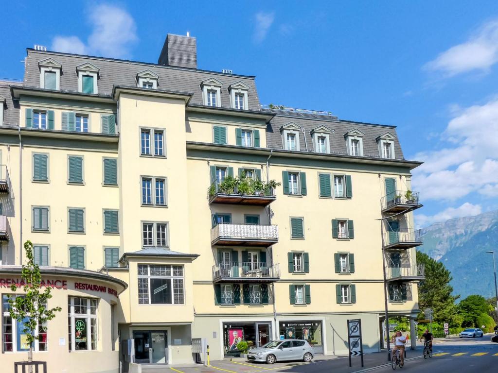 インターラーケンにあるApartment Orya by Interhomeの山前の大きな黄色の建物
