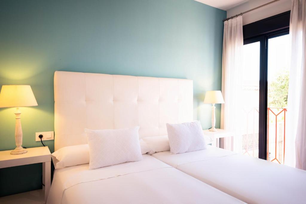 a bedroom with a large white bed with a window at Osario in Córdoba
