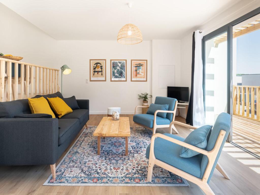 een woonkamer met een bank, stoelen en een tafel bij Holiday Home Palot 45 by Interhome in Mimizan