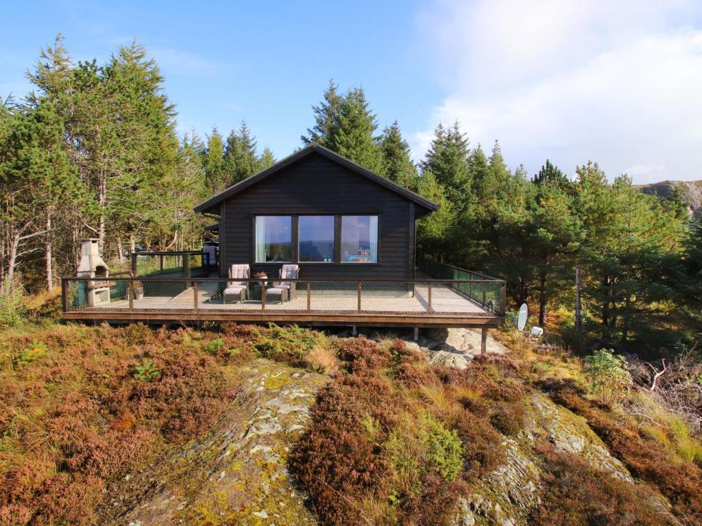 a house on a hill with two chairs on a deck at Holiday Home Havbu by Interhome in Korssund