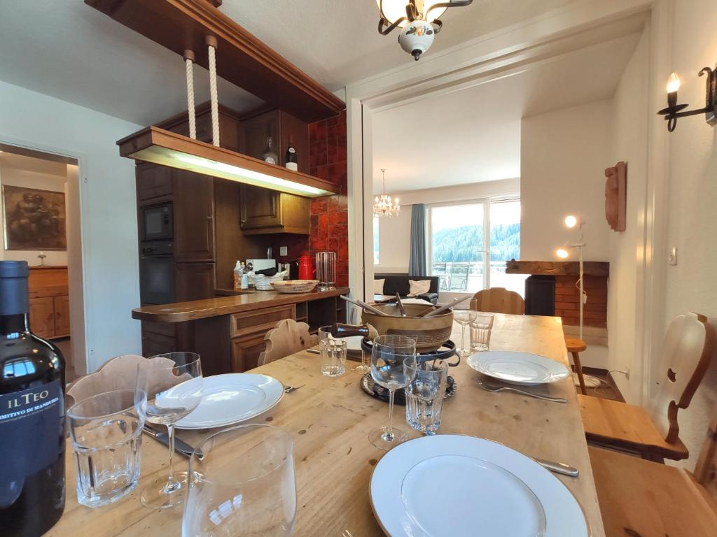 a dining room table with glasses and a bottle of wine at Apartment Regina by Interhome in Davos