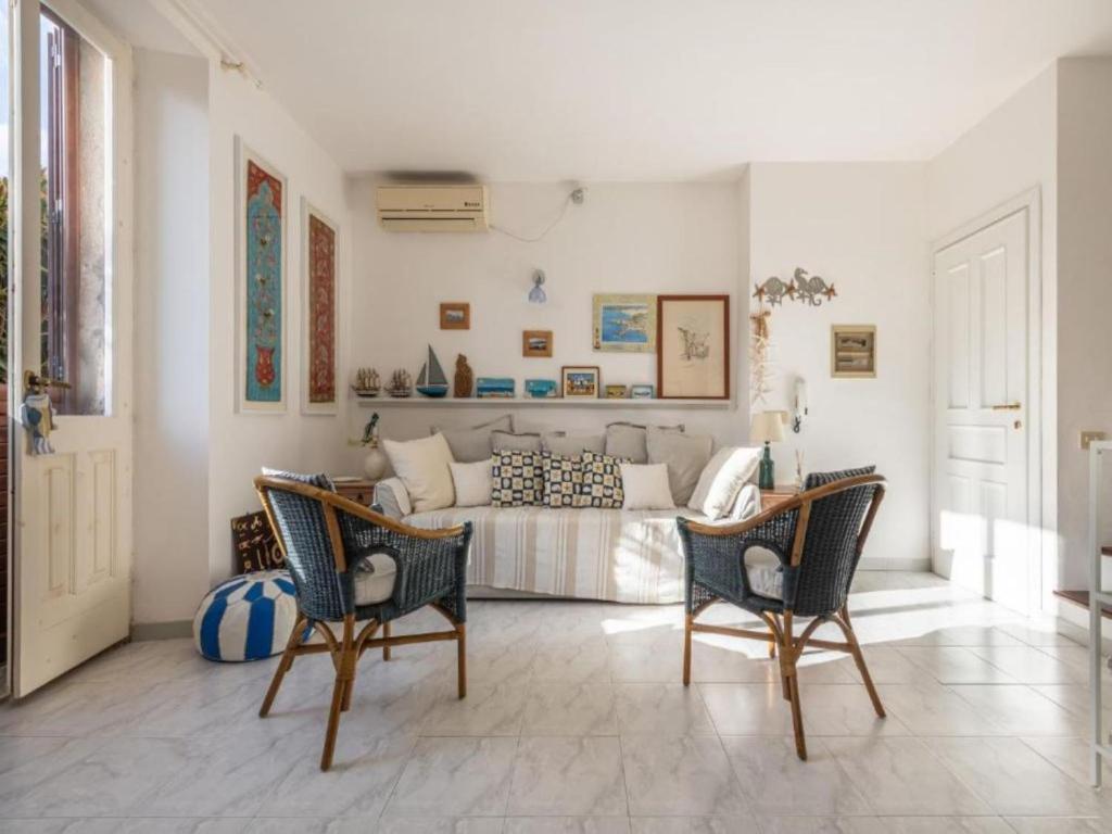 een woonkamer met een bank en stoelen bij Apartment L'appartamento nel Corso by Interhome in Carloforte