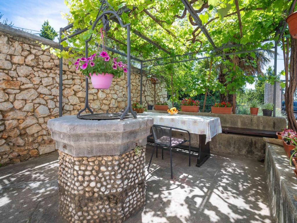 een patio met een tafel en een bloempot bij Apartment Ivana by Interhome in Jadranovo