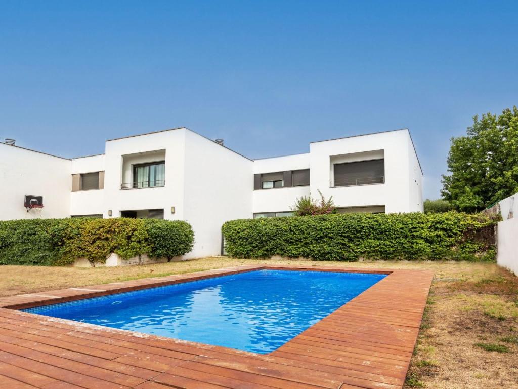 a villa with a swimming pool in front of a house at Holiday Home Pijoan by Interhome in Sant Antoni de Calonge