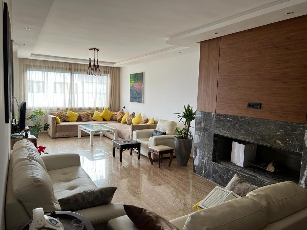 - un salon avec des canapés et une cheminée dans l'établissement Seaside - Luxury Living, à Dar Bouazza
