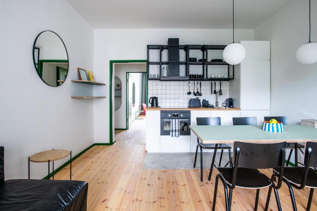 cocina y sala de estar con mesa y sillas en Flattering - Berlin, en Berlín