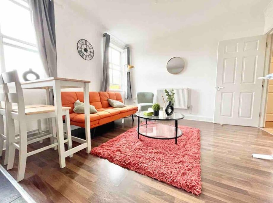 - un salon avec un canapé orange et un tapis rouge dans l'établissement Exquisite Luxury Retreat, à Southampton