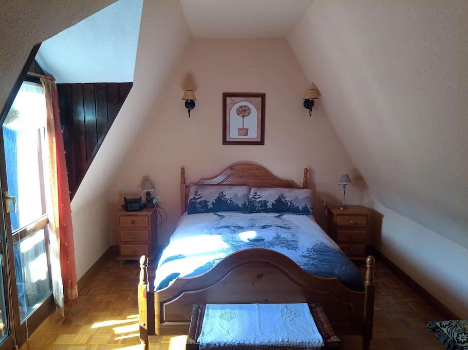 une chambre avec un lit dans un grenier dans l'établissement Ático en pleno pirineo, à El Pueyo de Jaca