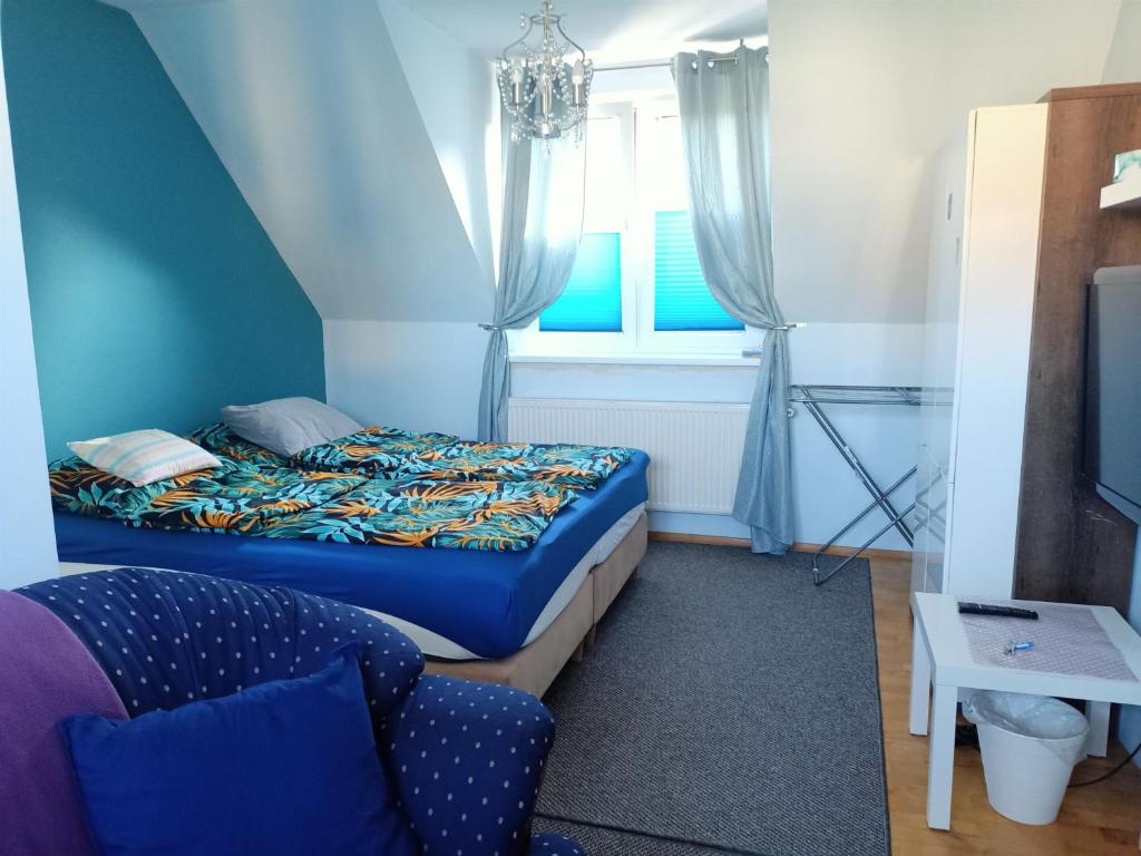 ein Schlafzimmer mit einem Bett, einem Sofa und einem Fenster in der Unterkunft Bukowy zakątek kwatera prywatna in Koszalin