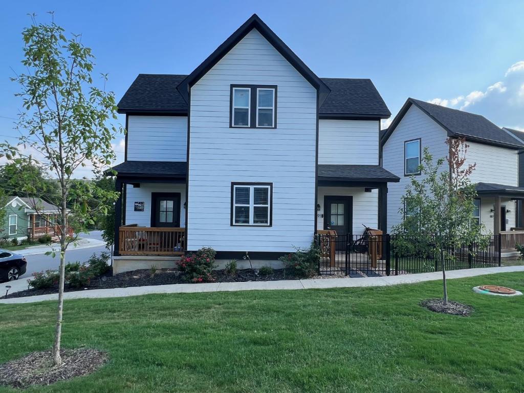 una casa blanca con un árbol en el patio en New Centennial Park Luxury Smart Home w Courtyard, en Fayetteville